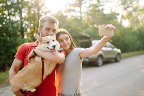 istock Young couple together with their beloved pet on a walk doing selfie 1487915256