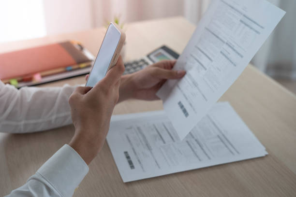 istock Businessmen use mobile phones to scan barcodes to access accounting information within the company. 1487921937