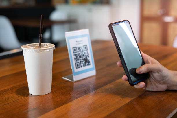 istock Men use phones to scan a qr code to select a menu or scan to receive a discount or pay for food and drink inside a cafe. using the phone to transfer money or pay online without cash concept. 1487922135