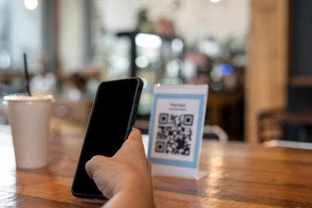 istock Men use phones to scan a qr code to select a menu or scan to receive a discount or pay for food and drink inside a cafe. using the phone to transfer money or pay online without cash concept. 1487922136