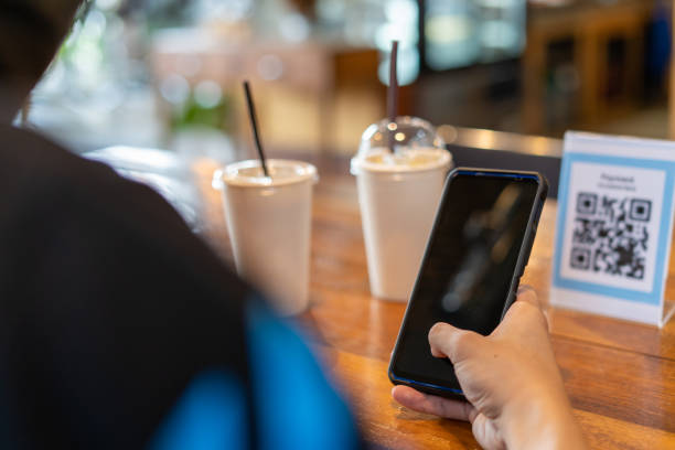 istock Men use phones to scan a qr code to select a menu or scan to receive a discount or pay for food and drink inside a cafe. using the phone to transfer money or pay online without cash concept. 1487922153