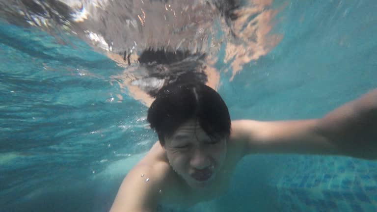 Young man swimming in blue clear under water