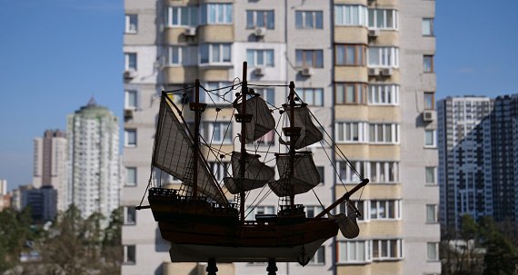 Defocused Cityscape Panorama With Wooden Sailing Ship Model On A Foreground