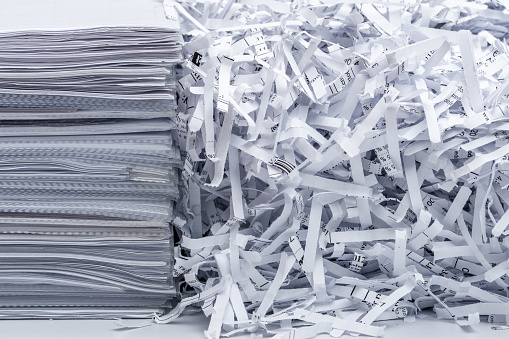 A stack of company documents next to recycled papers