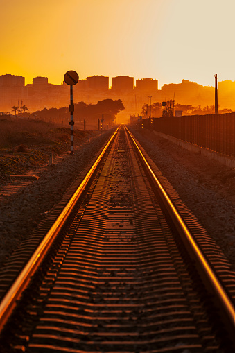 Sunset light falls over a deserted railroad and the city skyline