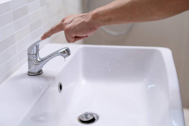 istock Save water. Man keeps turning off the running water in the bathroom to protect environment. Greening planet, reduce global warming, Save world, life, future, risk energy, crisis , water day. 1487933299
