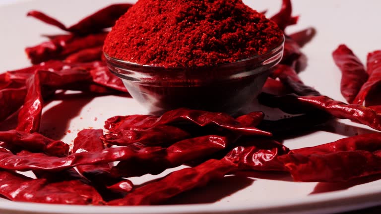 Cayenne pepper (Ground chili) and dried chili on white background. Table spin view.