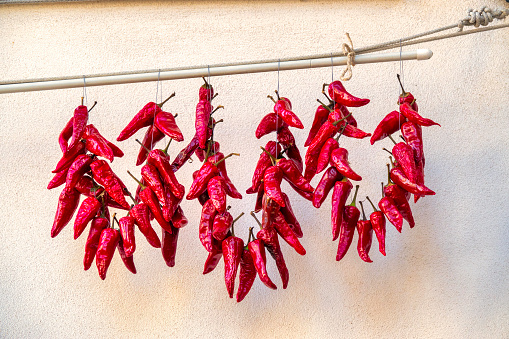Sun drying chili peppers on a wall in Pianella, Italy