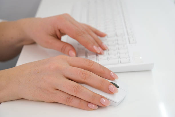 istock Close-up of hands woman using a mouse and keyboard computer 1487936863