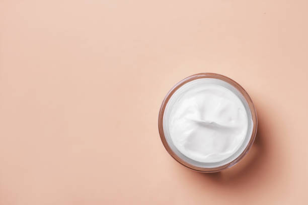 istock Cream jar of white on a beige background. 1487936868