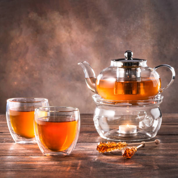 istock Black tea in a glass teapot and cups. On a dark background. Tea concept. 1487937608