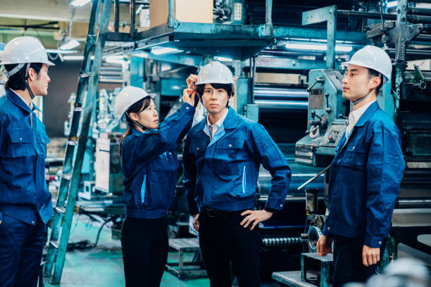 istock Factory workers checking each other's safety equipment 1487939269