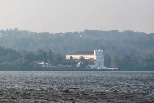 Old Goa, India - January 2023: An ancient Portuguese era church rising above the Mandovi river in Goa.
