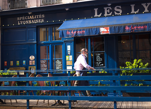 Postcard view at classic street cafe-shop in Paris, France (the building on the left hand is Louvre)