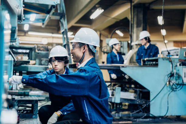 istock Workers servicing machinery at the factory 1487941726