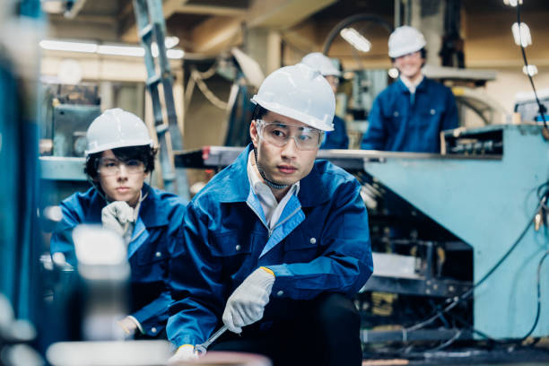istock Workers servicing machinery at the factory 1487941732