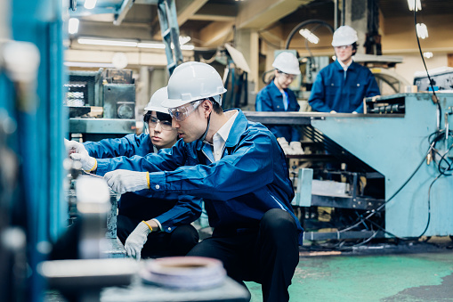 Workers servicing machinery at the factory