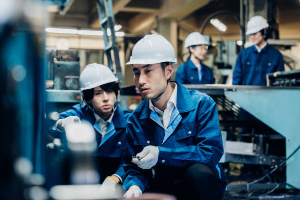 istock Workers servicing machinery at the factory 1487941740