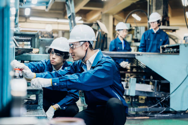 istock Workers servicing machinery at the factory 1487941742