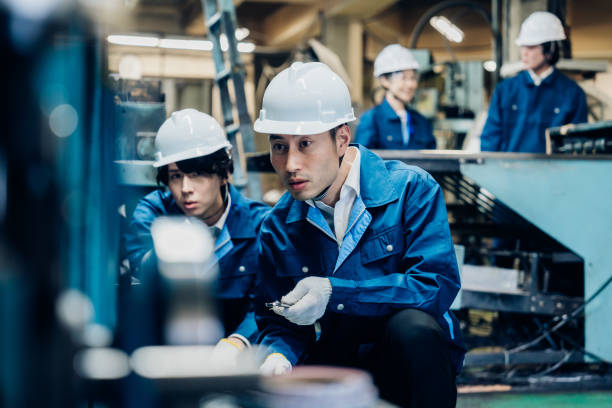 istock Workers servicing machinery at the factory 1487941743