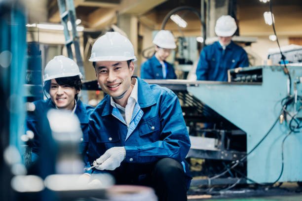 istock Workers servicing machinery at the factory 1487941760