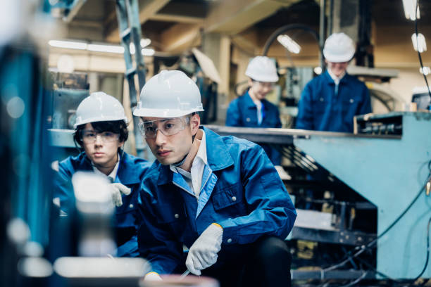 istock Workers servicing machinery at the factory 1487941761