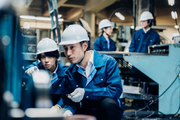 istock Workers servicing machinery at the factory 1487941767