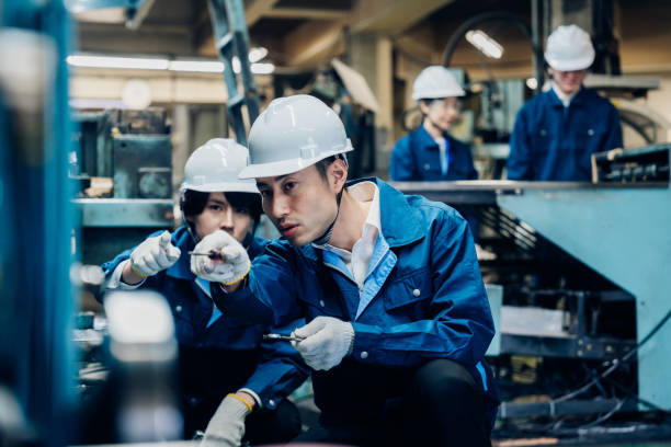 istock Workers servicing machinery at the factory 1487941785