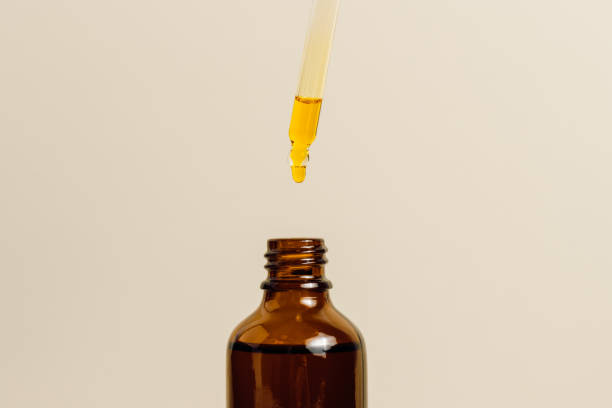 istock Cosmetic oil drop falls from pipette in glass bottle. 1487944005