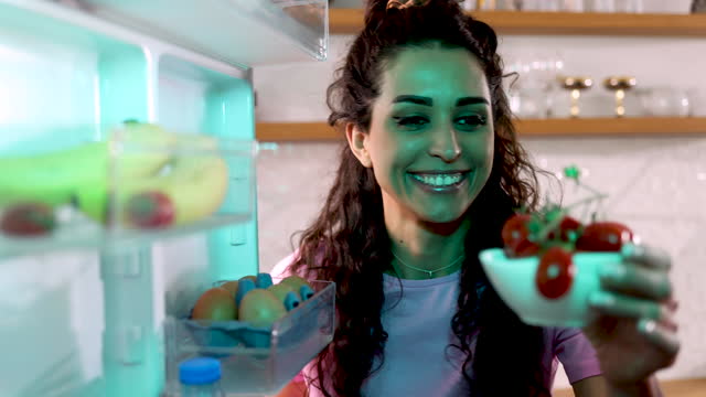 Woman looking at food in refrigerator