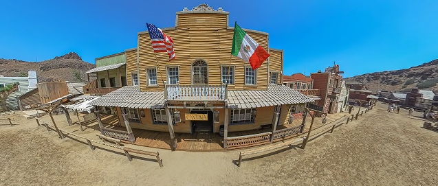 Sioux City Park, Gran Canaria - April 2023: aerial view of the saloon with American flag and Mexican flag. Main street of western-themed amusement Sioux City park by the Aguila canyon of Gran Canaria.