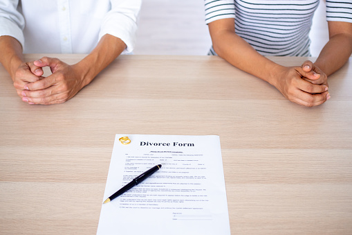 Lovers with a divorce contract and a ring on the table Divorce, filing divorce documents or prenuptial agreements made by lawyers
