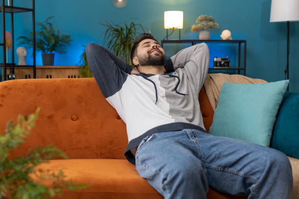 istock Tired young man lying down on comfortable couch, taking a rest, daytime nap relaxing falling asleep 1487944888