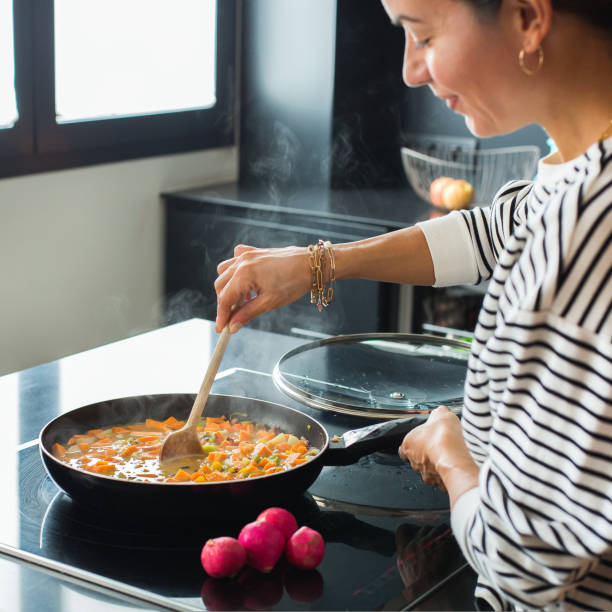 istock Woman hands adding ingredients in a vegetable stew 1487947158