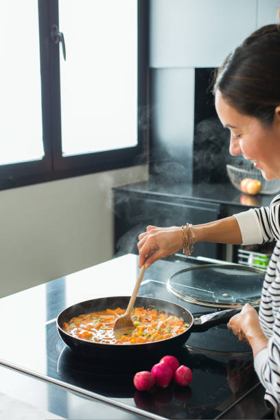 istock Woman hands adding ingredients in a vegetable stew 1487947212