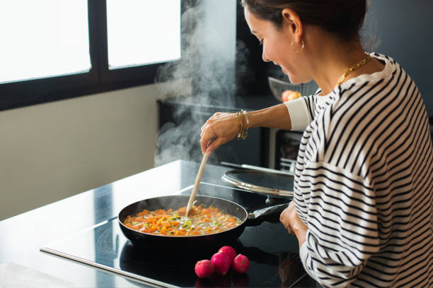 istock Woman hands adding ingredients in a vegetable stew 1487947263
