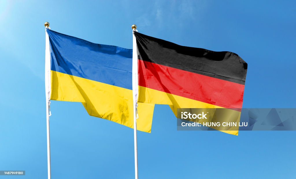 Flags of Germany flag and Ukrainian flag. Waving in blue sky Ukrainian Flag Stock Photo