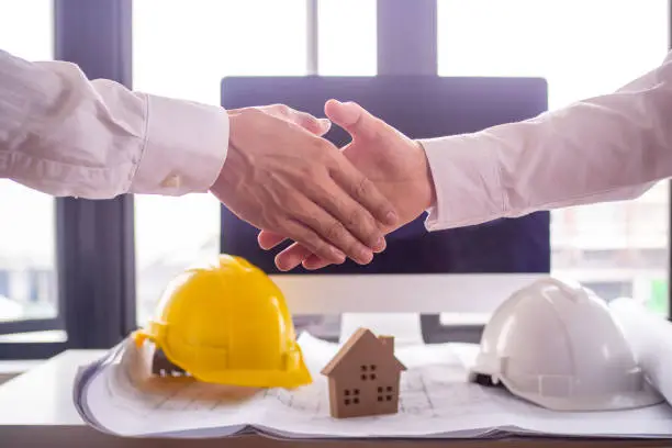 The construction team leader is going to shake hands with the leader engineer, start the construction site improvement project, cooperation and contractor.