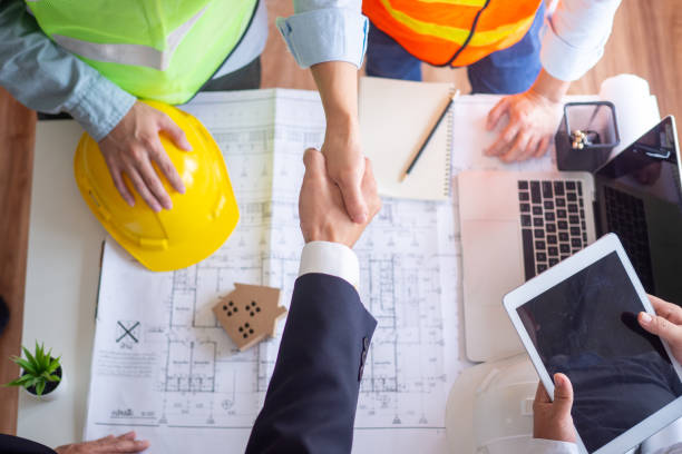 istock Shake hands after discussing the engineering collaboration agreement of the contractor team and the architects working together on the construction project 1487950003