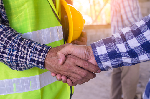 Construction worker team hands shaking greeting start up plan new project contract in office center at construction site, partnership and contractor concept