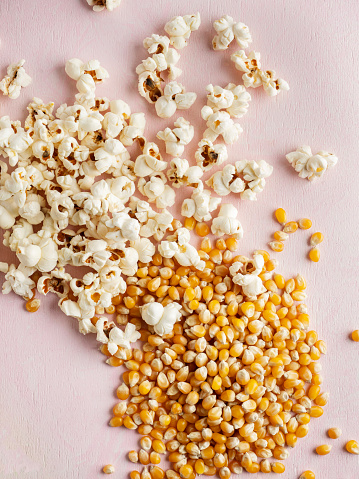 on the background of white salted popcorn, a bowl with a colorful, sweet delicacy