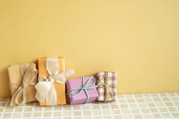 istock Gift boxes on table. yellow background. anniversary birthday party concept 1487953532