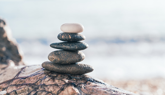 Rock stone stack balance on sea beach backgrounds, sign Zen meditation and peaceful