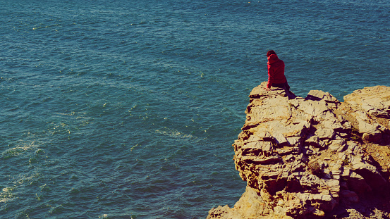 Tourist woman on spanish rocky coastline in Murcia region. Mediterranean Sea coast landscape, Calblanque Regional Park.