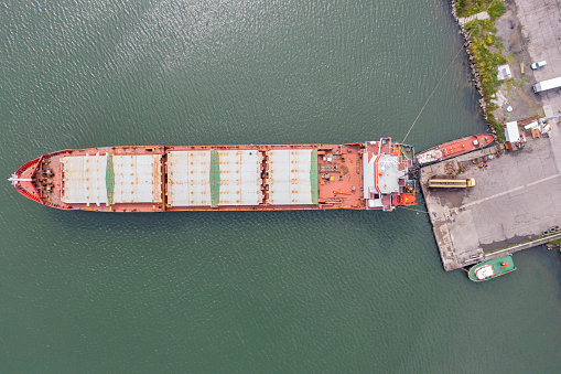 Aerial view cargo ship in port at container terminal port, freight ship standing in terminal port on loading, unloading container, Commercial cargo ship in sea port.