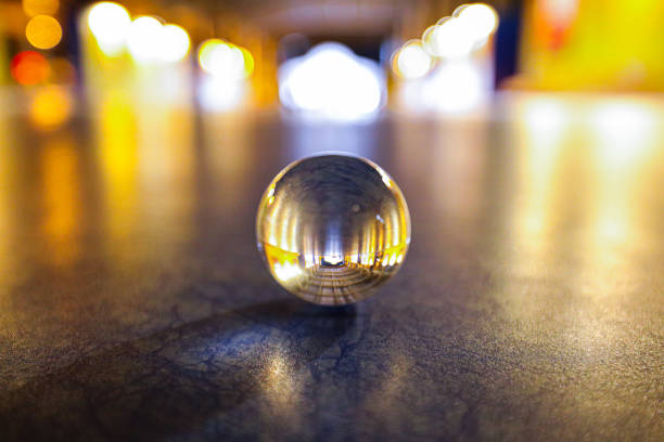 A lens ball on the floor at nighttime in low light, shallow depth of field & selective focus.