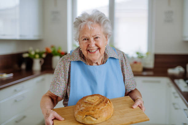 Portrait of senior woman with fresh baked bread. stock photo