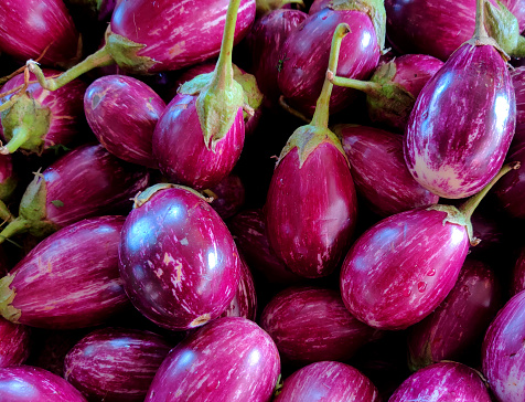 Long purple eggplant vegetable known as aubergine sliced on wooden table top view