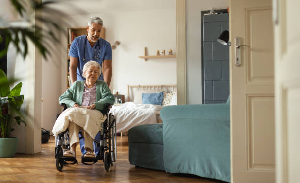 cuidador que realiza un chequeo regular de la mujer mayor en su hogar. - residencia de ancianos fotografías e imágenes de stock