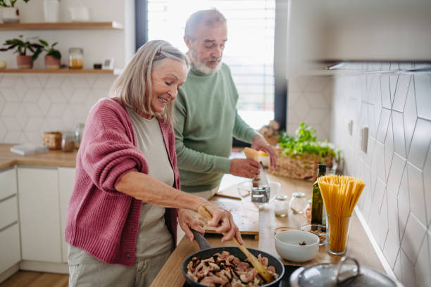 istock Senior couple cooking together in their kitchen. 1487981014